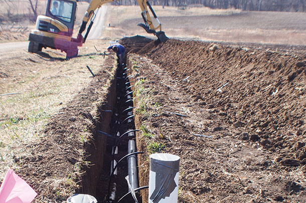 Drip tape is attached to a PVC feeder line at the top of the field.