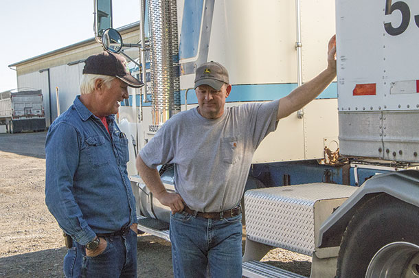 Doug Eldred talks business with a hay customer George Holmes
